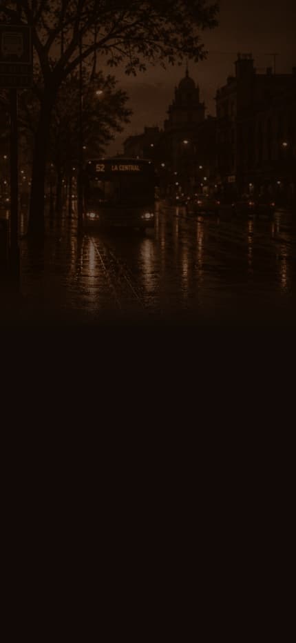 A rainy city street at night with a bus stop and an approaching bus